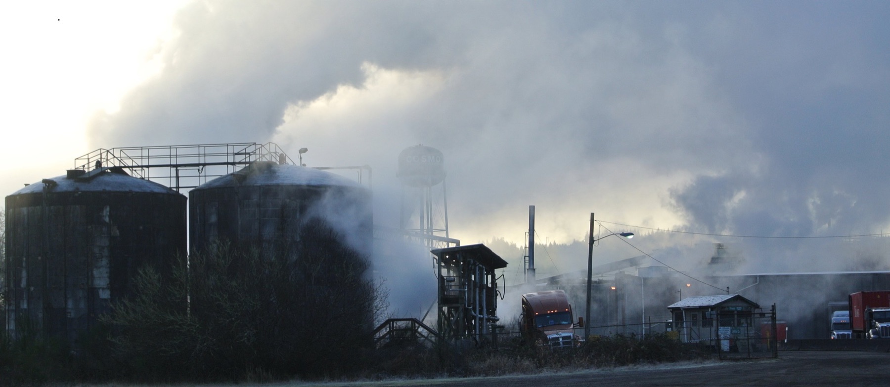 Industrial silos shrouded in smoke and haze